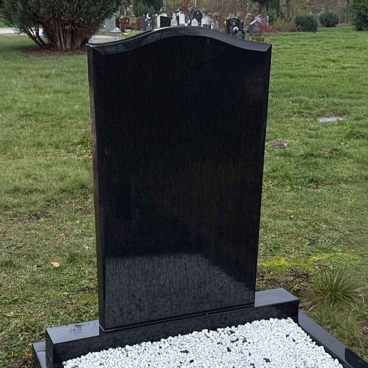 Muslimischer Grabstein Meleph: schlichte schwarze polierte Stele mit geschwungener Oberkante auf Sockel Hauptbild